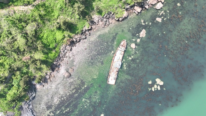 航拍俯瞰夏季海岸边搁浅的一条荣成渔船