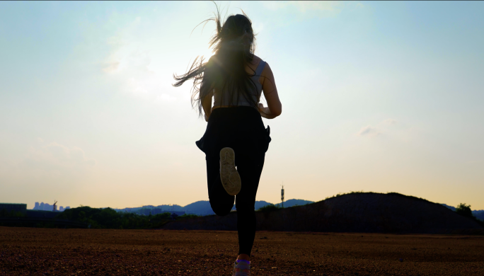 落日时分快乐的女孩在奔跑跑步锻炼身体阳光