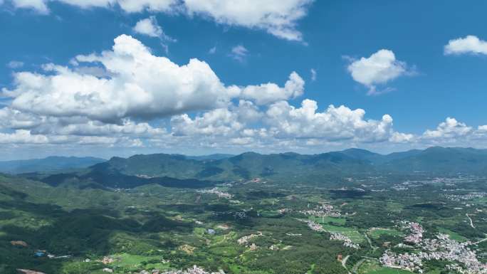 航拍升镜头高空旋转晴空蓝天白云村镇山地