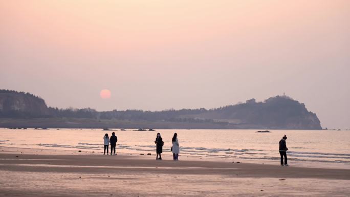 海边年轻人拍照看风景日出日落