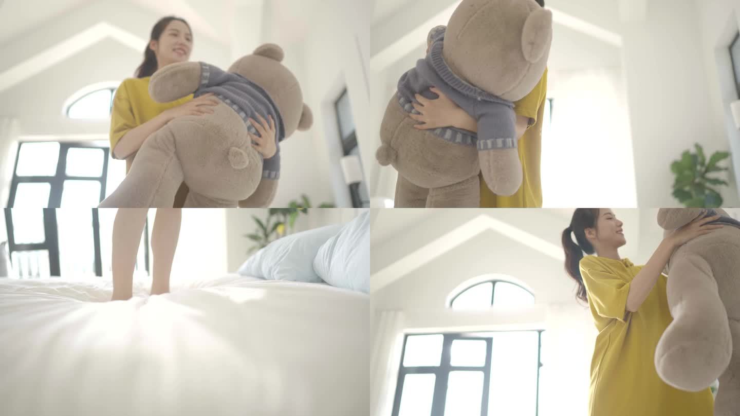 女生抱着玩具熊在床上跳舞