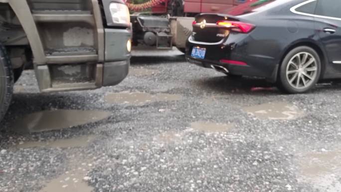 车流通过低洼积水公路雨后烂路汽车轮胎通过
