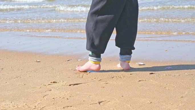 夏天孩子在海边海滩上赤脚奔跑玩耍的慢镜头
