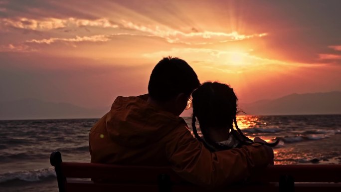 日落时分浪漫情侣在水边相见拥吻