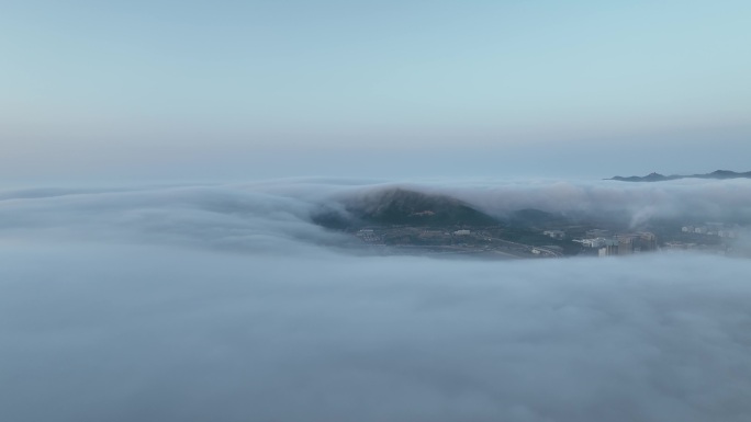 航拍平流雾中的威海远遥烟墩山与金海滩