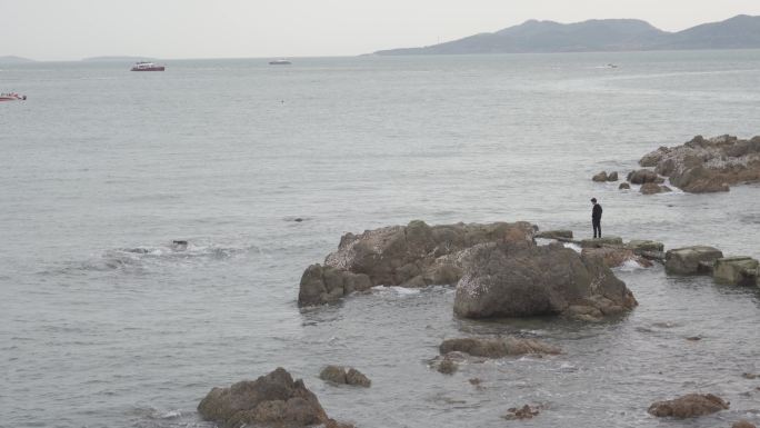 海边礁石站着一个孤独的人