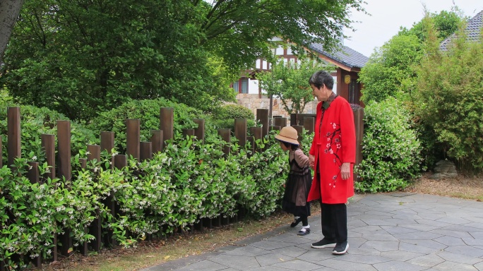 老人牵着孙女在湿地公园散步