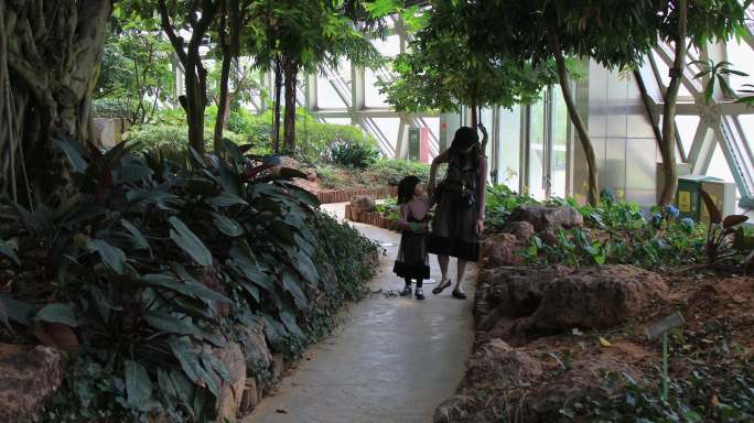 妈妈带着女儿在热带植物园游玩