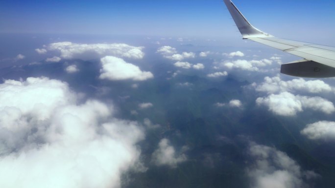飞机机翼在云海中穿行飞机翅膀窗外机舱窗外