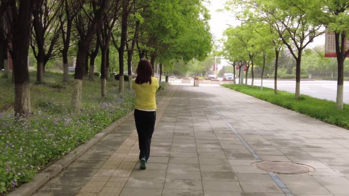 在城市街道散步锻炼的女人背影
