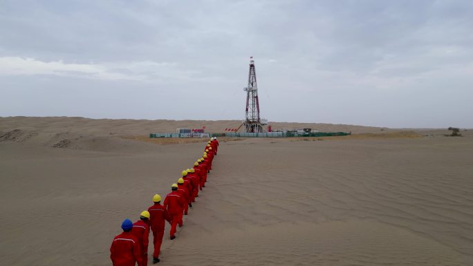 石油钻井工人沙漠里列队走向井架