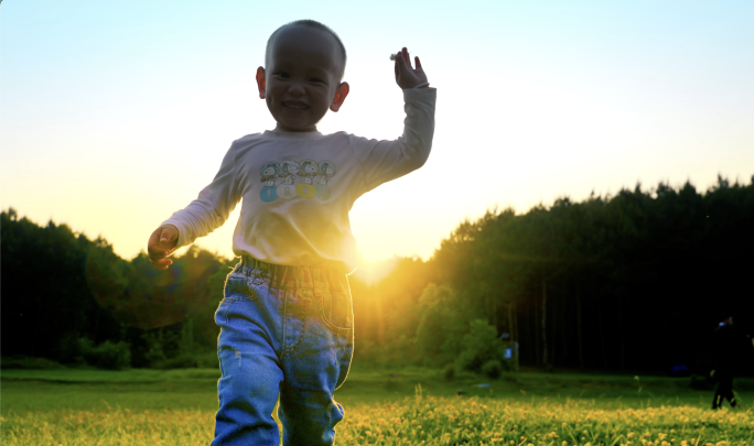 小孩草地上快乐奔跑可爱小男孩追着镜头奔跑