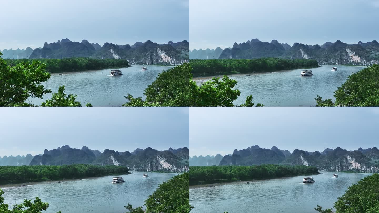 阳光下桂林漓江两岸的山和水上的游船