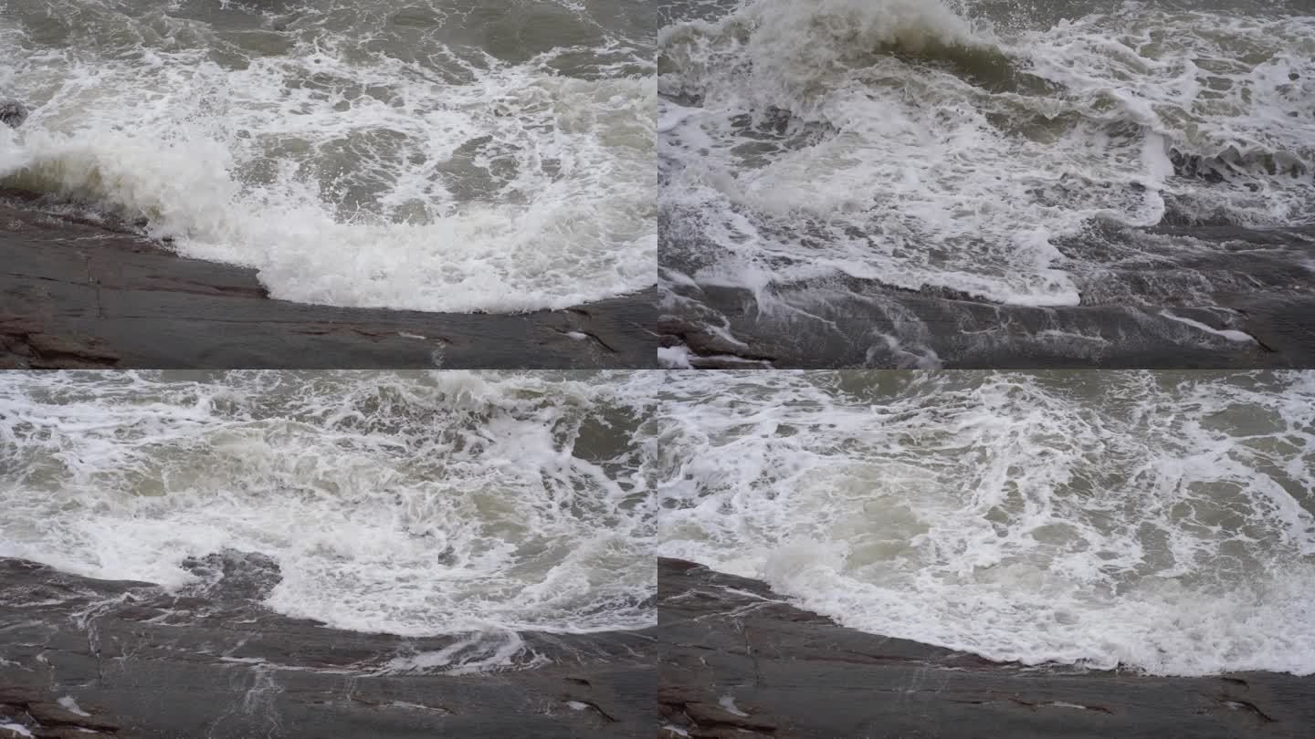 海浪拍打岩石浑浊海水冲刷礁石浪花阴天大海