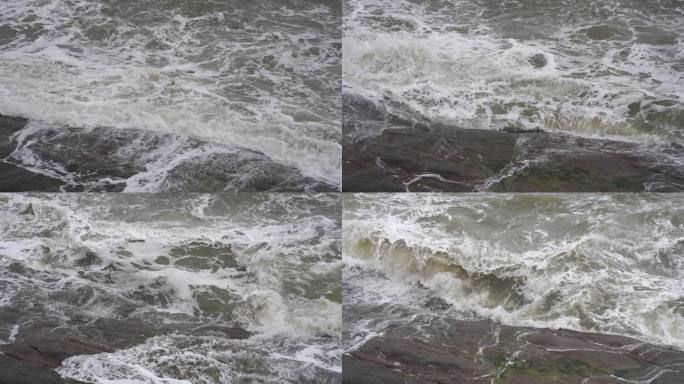 海浪拍打岩石浑浊海水冲刷礁石浪花阴天大海