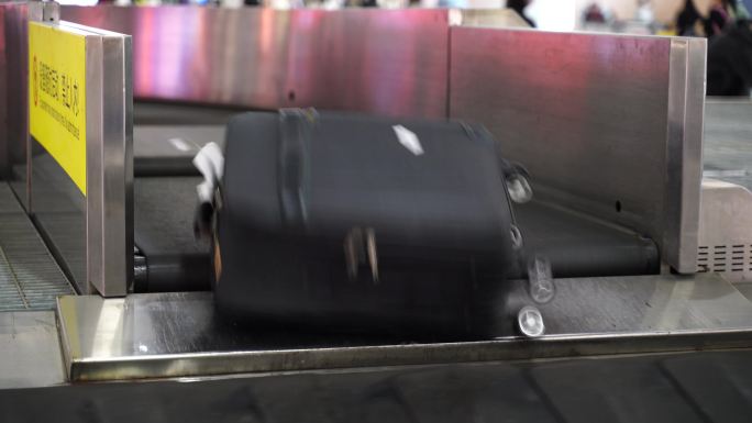 机场行李提取区转盘上移动的行李箱旅行包