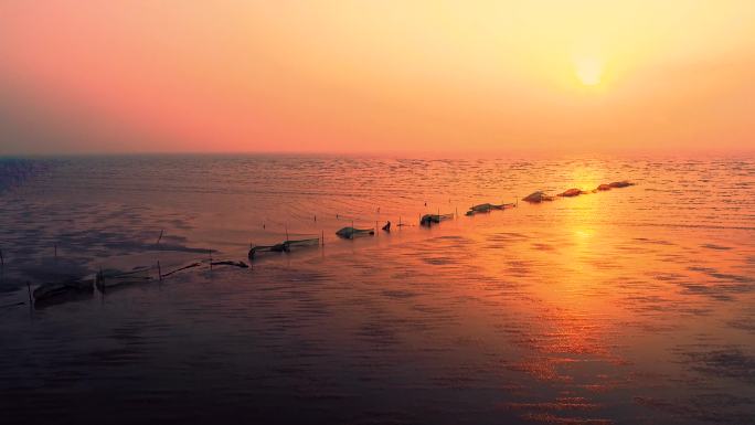 航拍渔民迎着朝阳在黄海边围网捕鱼
