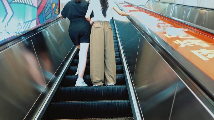 两个女人在商场电梯的背影