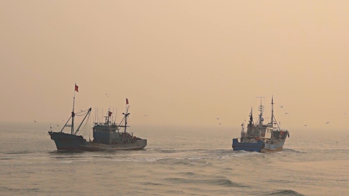 渔港黄昏出海和回港的渔船