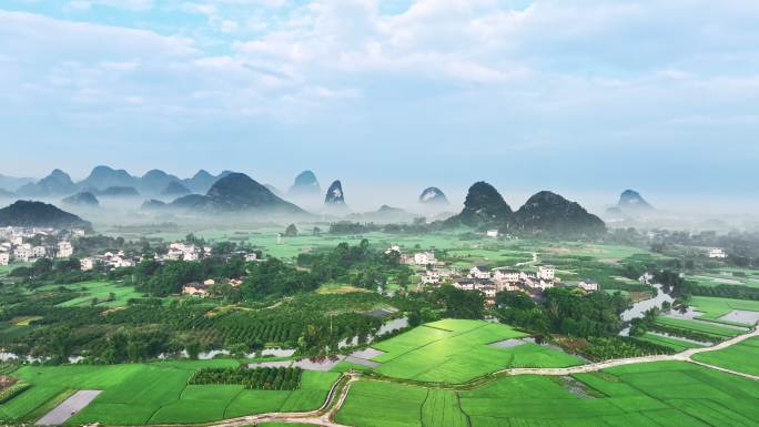 夏天的早晨桂林村庄和稻田上漂浮着一层薄雾
