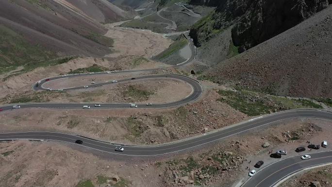 航拍行驶在新疆独库盘山公路上的汽车