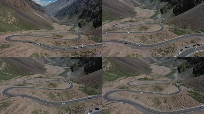 航拍行驶在新疆独库盘山公路上的汽车