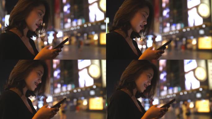 美女商人夜晚城市街头使用手机