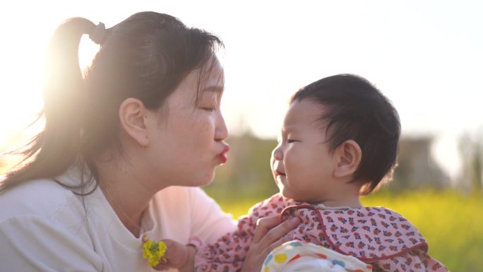 妈手拉手孩子 油菜花 油菜花地 亲吻小孩