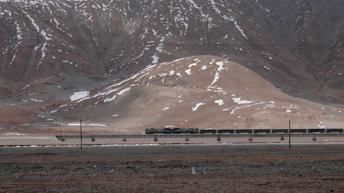 玉珠峰下行驶在青藏铁路上的火车