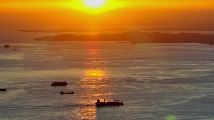 日出时分福建厦门湾海面上出港的货轮