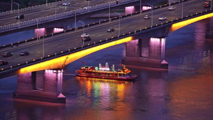 中国哈尔滨游船穿过松花江公路大桥