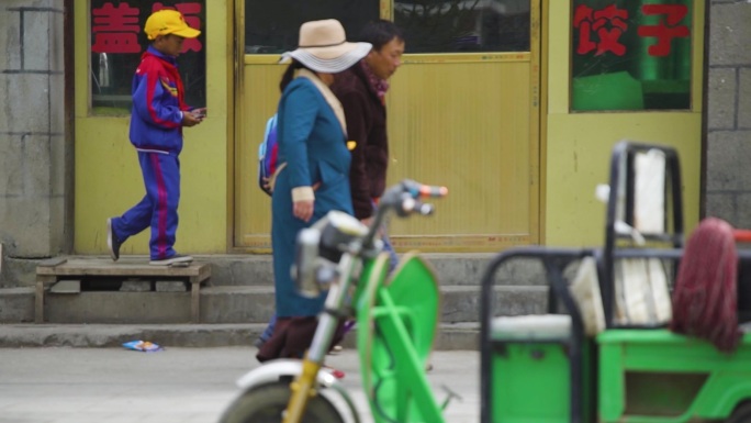 三轮车 一家人走在大街上 接孩子放学