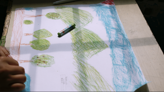 小学生在纸上画画 蓝天白云青山绿水