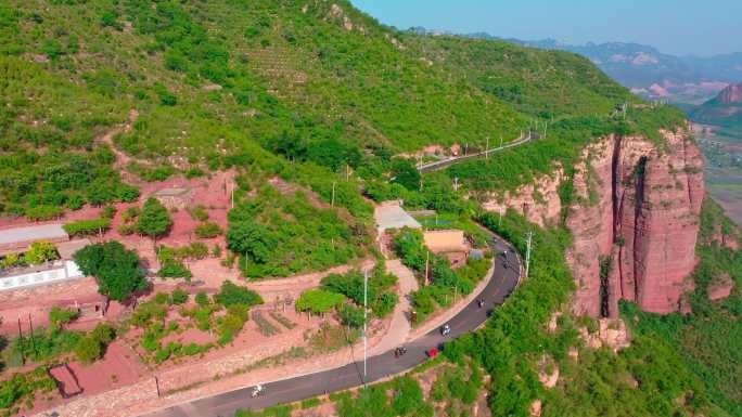 航拍骑行在山村道路的摩托车队