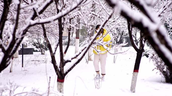 冬天在挂满雪花的树林走路看书的女孩