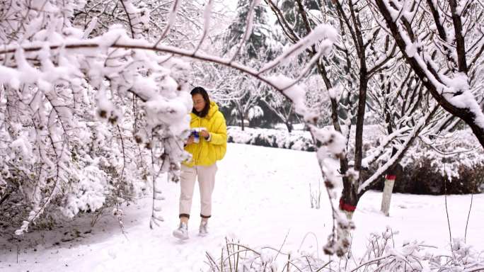 大雪覆盖的树林中散步看书的女老师