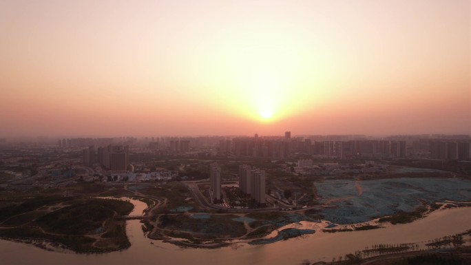 黄昏城市密集建筑工地河流前飞