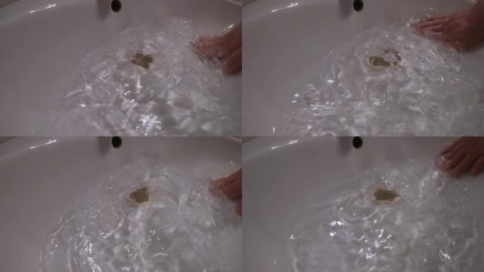 手在放水的洗脸池里搅拌清理洗手池