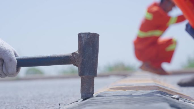 道路养护工人安装减速带汗流浃背慢动作