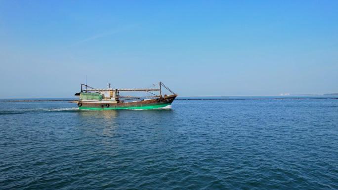 渔船在海上行驶，碧海蓝天