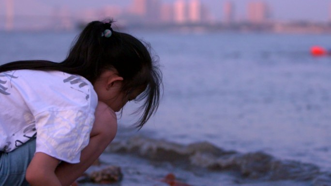 武汉武昌江滩傍晚夕阳余晖下玩水的女孩