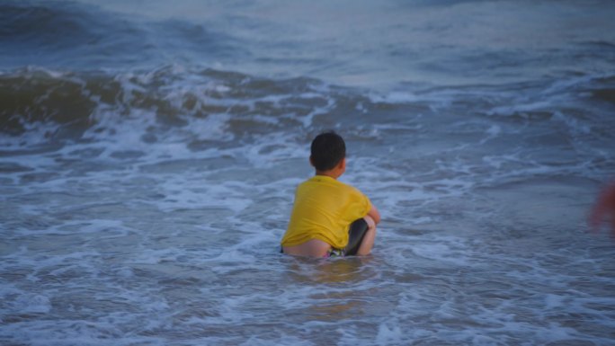 海边玩水冲浪的小男孩