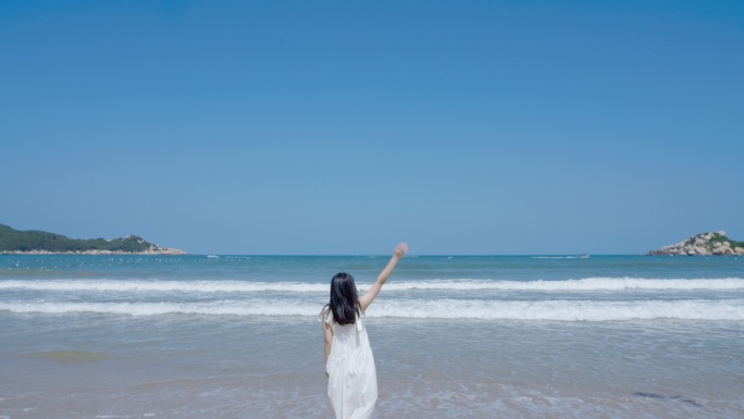 海边少女对着大海欢呼跳跃挥手
