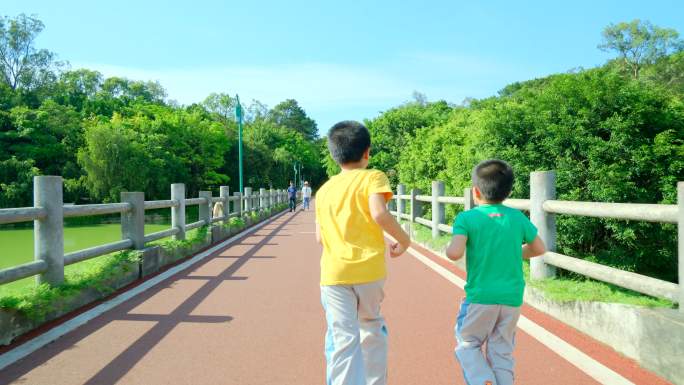 两个小孩在公园跑道跑步过桥 向前冲