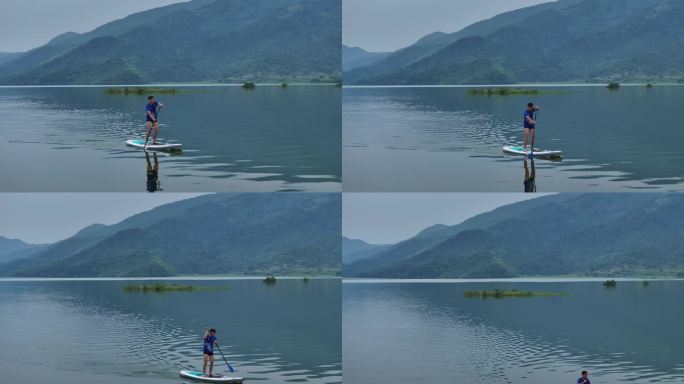 一名男子站在水板上，夏季户外划船