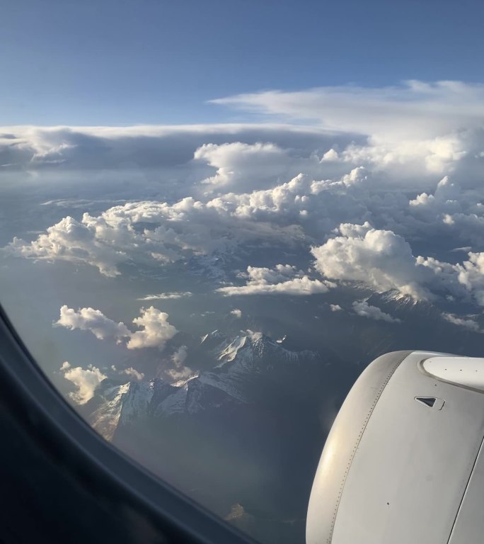 飞机旅行飞过意大利北部雪山的壮观云海景象