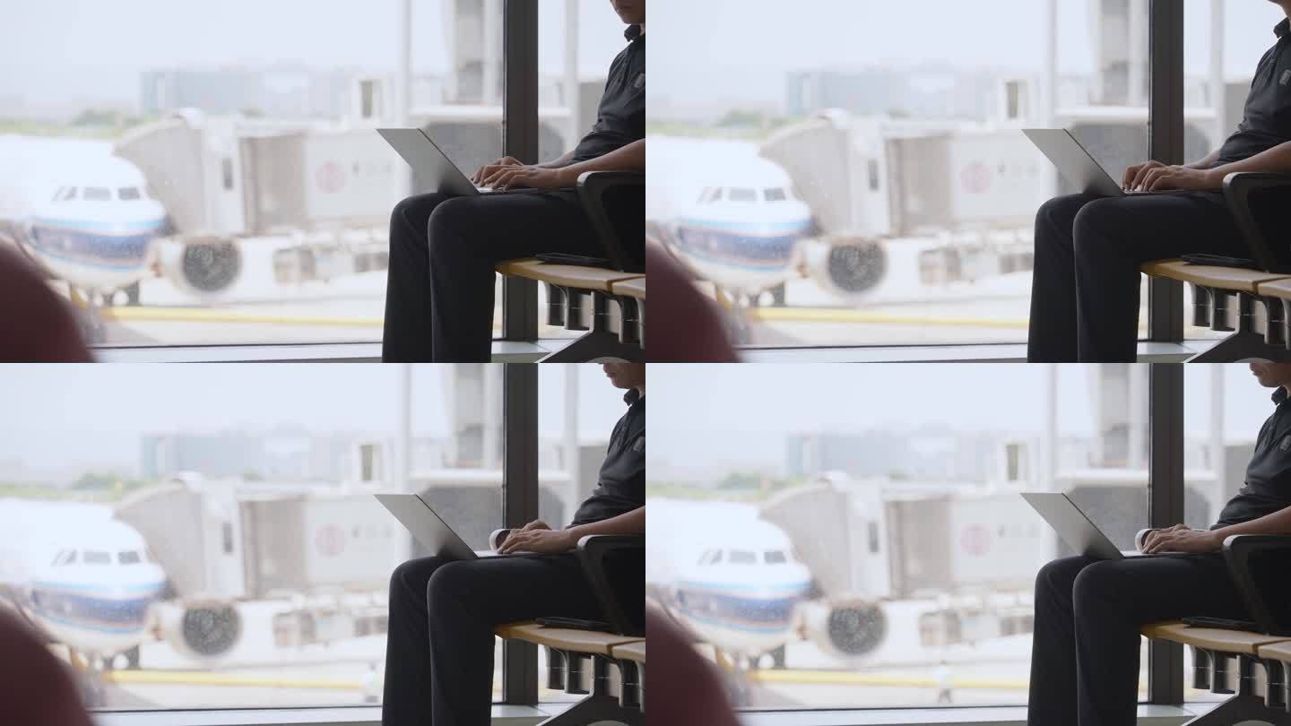 男子出差途中在机场用笔记本电脑办公