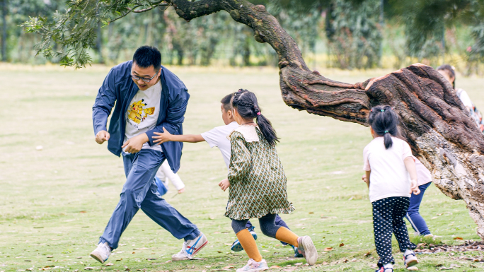 公园草地父母陪伴孩子开心玩耍幸福生活