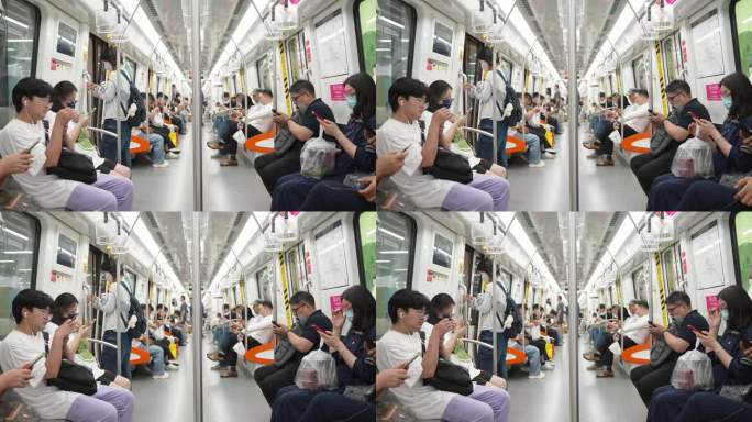 地铁车厢内使用手机的人群