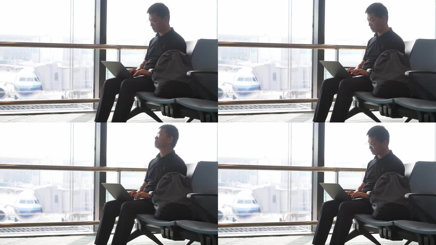 男子出差途中在机场用笔记本电脑办公